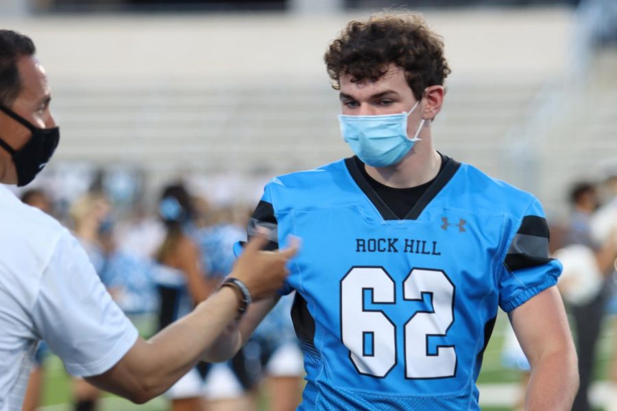 Jared Bart high fives football coach Mark Humble while walking on the Children's Health Stadium field. Varsity football will play their first game at Frisco Heritage Thursday, Sept. 24. 