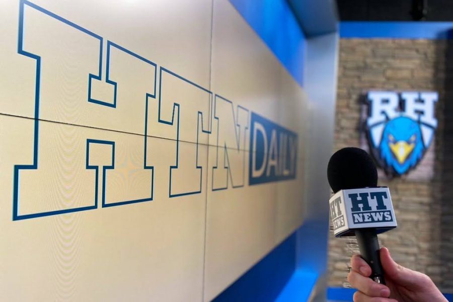 Hill Top News Daily reporter holds a newly-branded microphone in the broadcast studio. All media programs, Hill Top News, Hill Top Times, yearbook and Rock Hill Radio will celebrate Launch Day Tuesday. "Our show recipe is connect and captivate," senior and broadcast News Director Grant Johnson said. "We want to bring the student body together, and we want to make them engaged in our show and interact with us."