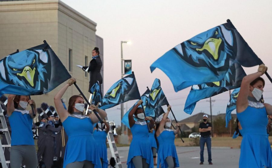 Senior Kaitlyn Cyranowicz performs with the rest of the Color Guard at the Ribbon Cutting event. The group showcased their flag skills while marching band played behind them. "Seeing a lot of people from town coming together was really cool and special since it is our second high school," sophomore and band member Valentina Vera-Gonzalez said. "Coming from someone who doesn't like fireworks, the fireworks that night were so stinking cool."