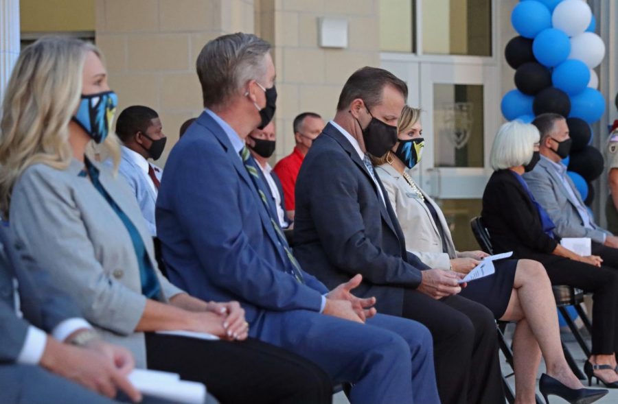 Former superintendent Drew Watkins sits with new superintendent Holly Ferguson. Assistant principals Dedrick Buckels, Melissa Weiss and other members of administration made appearances at the ceremony. The school offered cookies, waters and commemorative coins at the outside event.