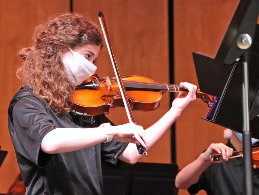 Violinist Gracie Clark plays at orchestra's holiday concert. Orchestra students performed in the new auditorium. Masks and COVID-19 precautions were used to ensure safety of all students and audience members. 