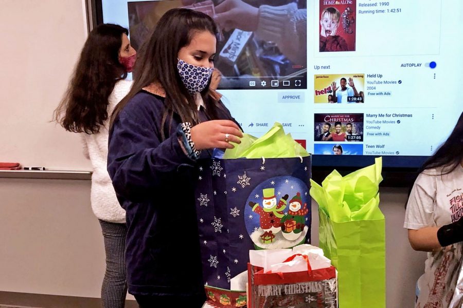 Spanish Honor Society member Xiomara Sanchez looks at the "white elephant exchange" gifts in Spanish teacher Elizabeth Dzvonick's room. The honor society offered food, a movie and two hours of holiday socializing. The society meets every month and holds service opportunities throughout the year. 