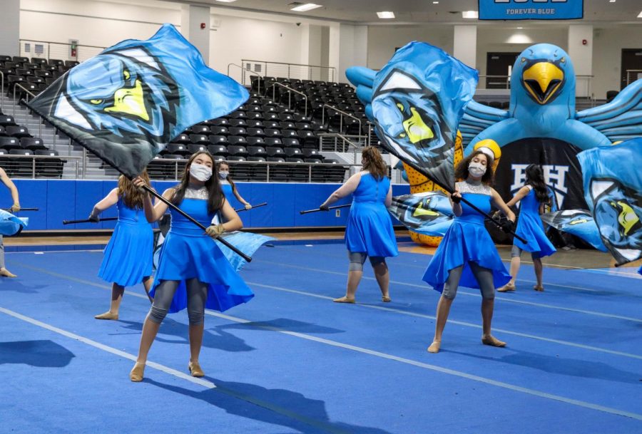 Color guard spins their flags at the Meet the Blue Hawks spring athletics event. The event featured performances by cheer and the Rockettes.