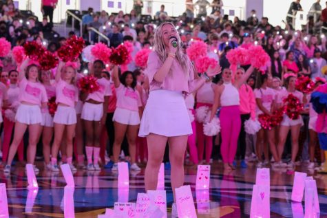 Junior Ashley Sallaway sings the song "Rise Up" to honor breast cancer survivors at the Pink Out pep rally.