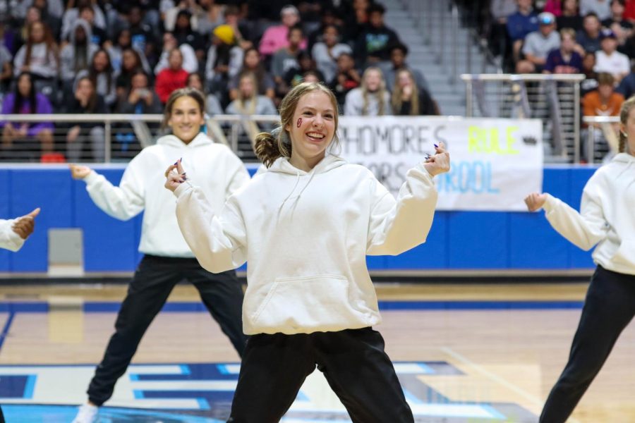 With a smile on her face, senior Nicole Bitner performs the dance routine with the class of 2023 cheerleaders, Rockettes and varsity football players.