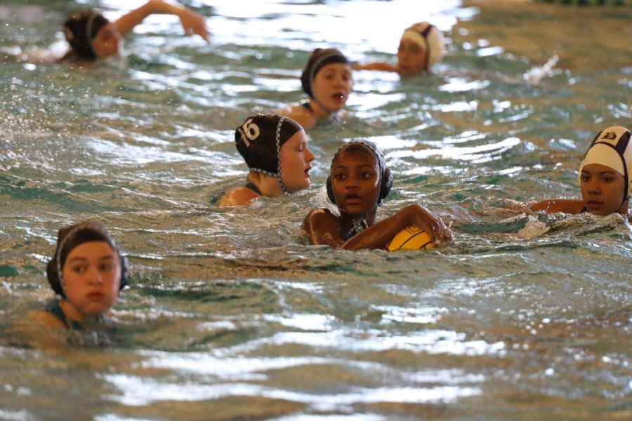 Girls water polo team holds the ball to execute a goal for their team. "I spend an hour before the game with the team, and we talk about strategies," junior, Na'myah Turner said, "We get closer to understand what we should do to move as one in the water." The end score was 16-6 for the girls.