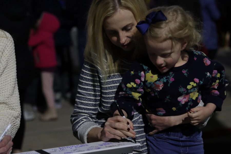 To show their presence at the event, a mom and her daughter sign one of the beams. 