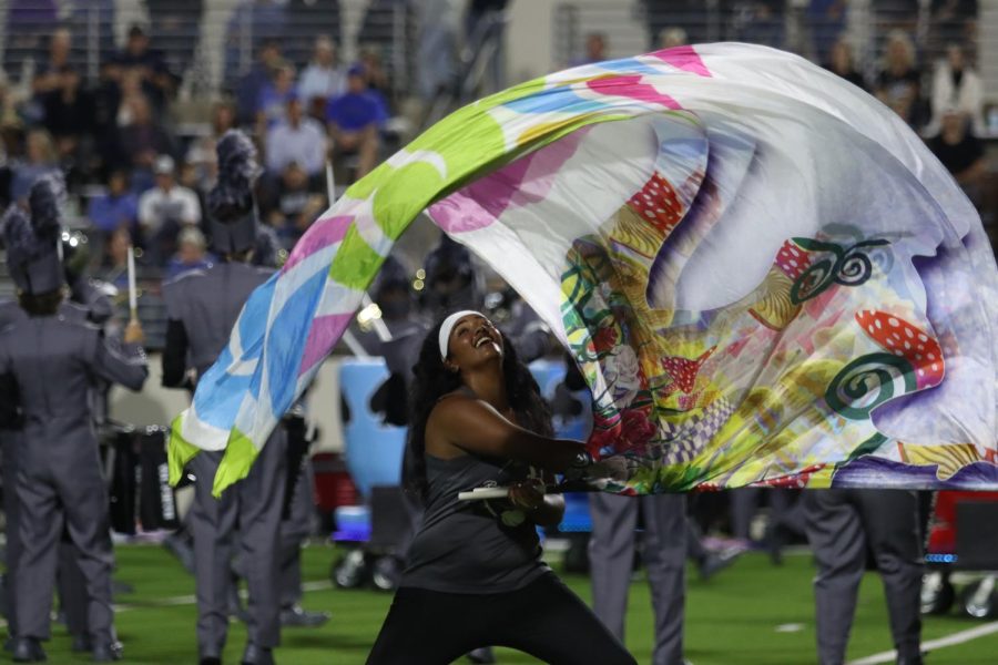 Sophomore Oviya Omprakash is part of the Rock Hill Color Guard as well as the Bollywood Dance Club. "I joined color guard to try something new," Omprakash said. She is pictured swinging a flag at the game versus Denton.