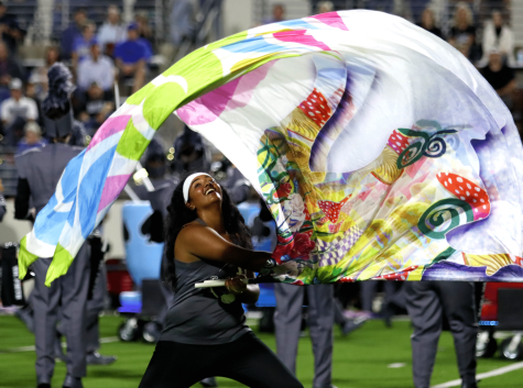 Sophomore Oviya Omprakash is part of the Rock Hill Color Guard as well as the Bollywood Dance Club. "I joined color guard to try something new," Omprakash said. She is pictured swinging a flag at the game versus Denton.