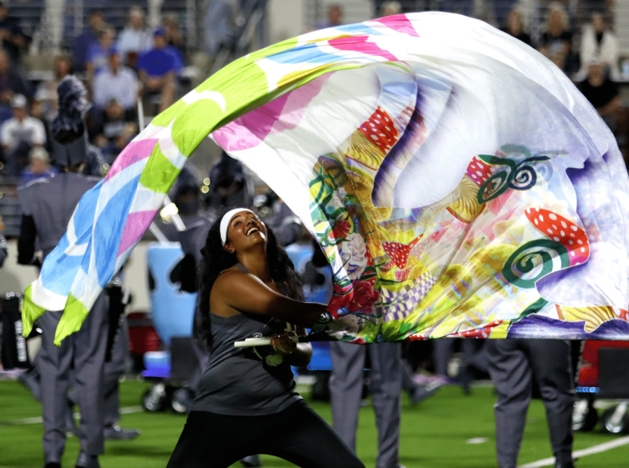 Sophomore Oviya Omprakash is part of the Rock Hill Color Guard as well as the Bollywood Dance Club. I joined color guard to try something new, Omprakash said. She is pictured swinging a flag at the game versus Denton.