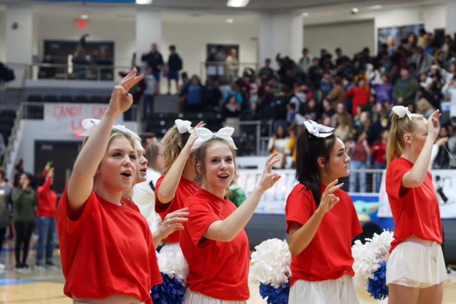 Before the the winners of the spirit stick were announced, senior Nicole Bitner puts her hand up and sings along to the alma mater.