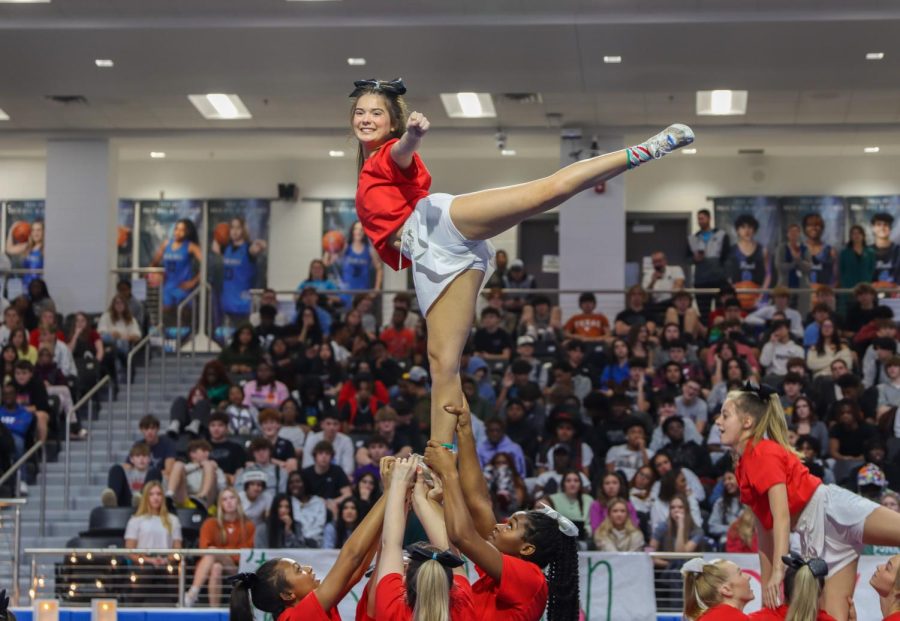 With a smile on her face, junior Abbie Mcswain strikes a pose in the air as a flyer. After the cheer team performed, the cheer abilities team also made an appearance.