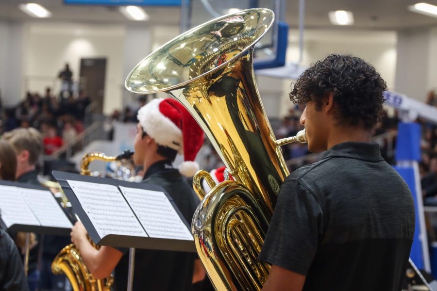 While reading the sheet music, senior Tristyn Dolan plays the Tuba at the holiday themed event.