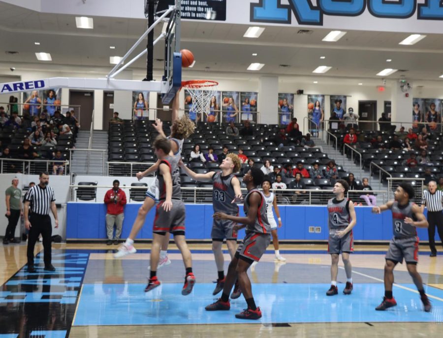 Soaring on top of the hoop, Blue Hawk Riley Shore attempts to make a basket. The next game will be with Allen High School on Tuesday, Jan. 17 at 7:15 p.m.