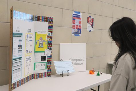 Junior, Cecilia Trieu, viewing one of the informational boards for the Rock Hill Expo night.