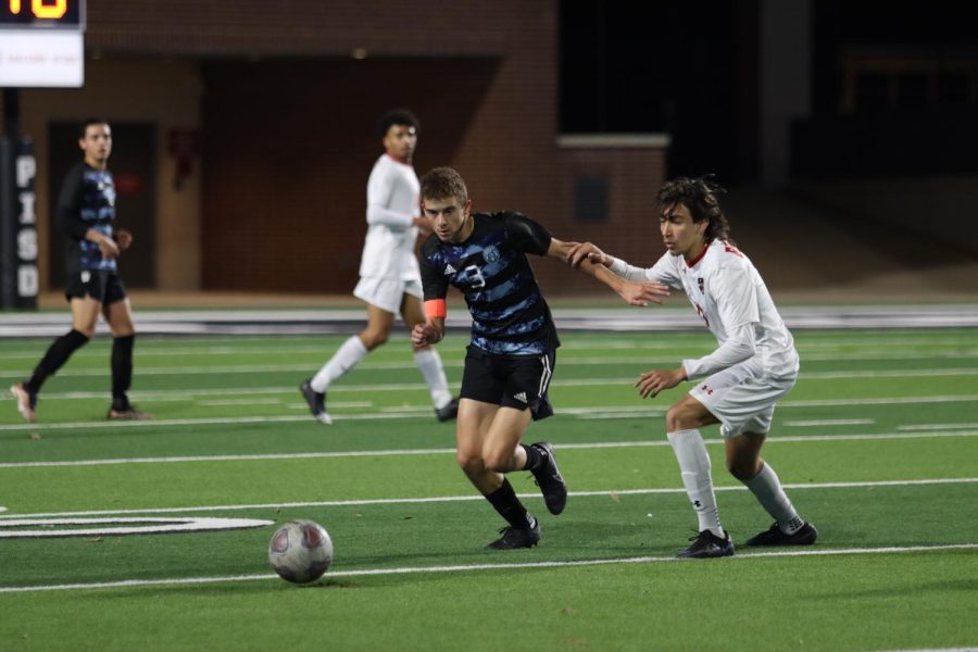 Senior Jake Loertscher tackles with his opponent as he drives the ball across. "My role was to try and keep possession, to win the ball in the middle of the field to ensure we had more chances on a goal," Loertscher said. 