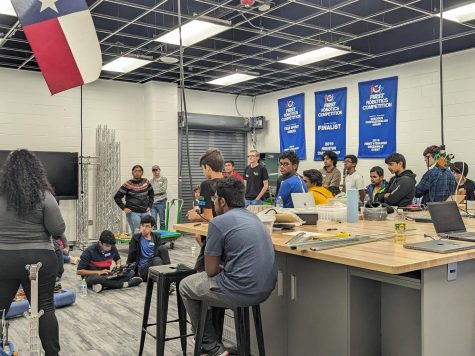 During every practice, the engineering students meet in the garage workspace to break down agendas and assign tasks. Pictured are students gathered facing the board. "One thing I've noticed being new to FRC is that collaboration is key," sophomore Jocelyn Lin said.  