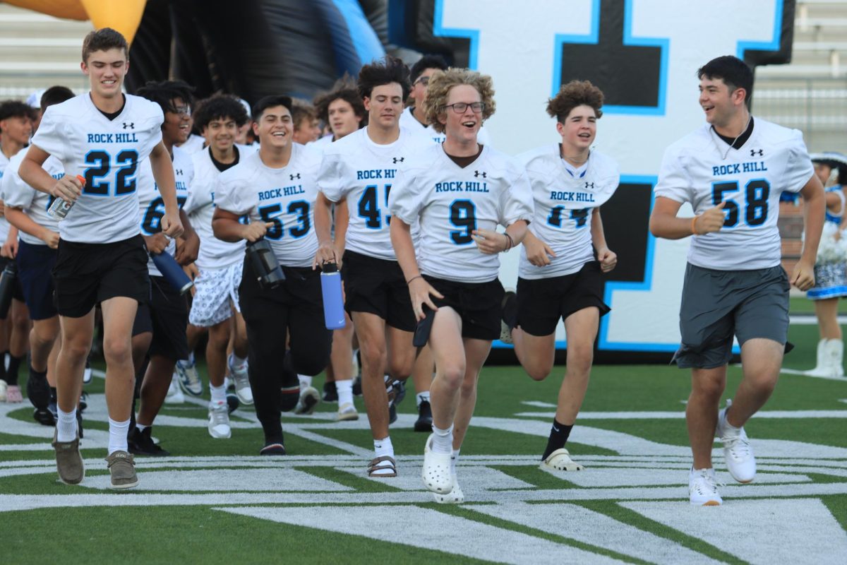 Running out onto the field, football gets applauded by the audience watching them. 