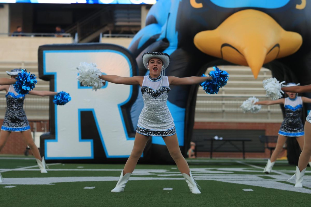 Dancing alongside fellow Rockettes, senior Caroline Hauge holds her arms out on either side during the choreography. 