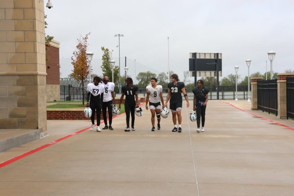 Seniors Chris Nguri, Nick Butler, Dylan Rhone, Victor Chionuma, Jonah Bowman, and Cyncere Lindsey walk inside together after morning football practice. "We’ve all went through things off the field, and we’ve all dealt with that together,” Dylan Rhone said. “Being able to just vocalize that with each other helps our bond so much.”