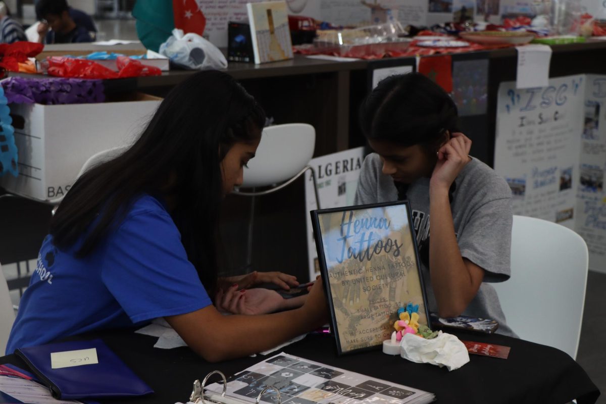 Senior Manvi Srivastava applies a henna stencil on freshman Rithika Pasupulate. A lot of people will think [henna] is just a religious thing, senior and Multicultural Society president Zeeya Merchant said. But no, not at all. Its a cultural thing that can be shared with everyone. The booth raised approximately $100.