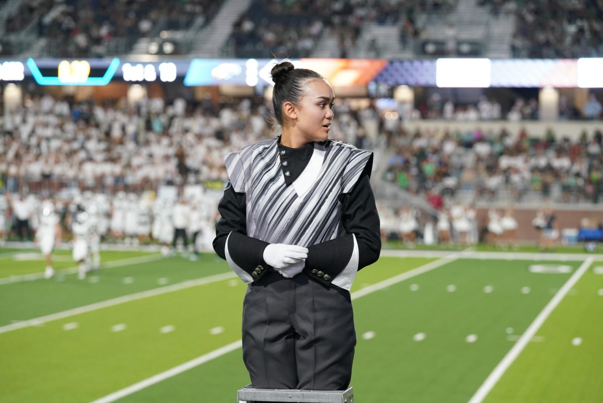 Senior Madi Kang stands on a podium at a football game. Being a drum major has definitely helped me, Kang said. Its helped me put myself out there, both socially and with my leadership.