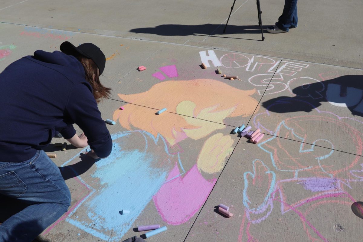 Utilizing every available tool at their disposal, this team is creating a chalk mural to represent Hope Squad.