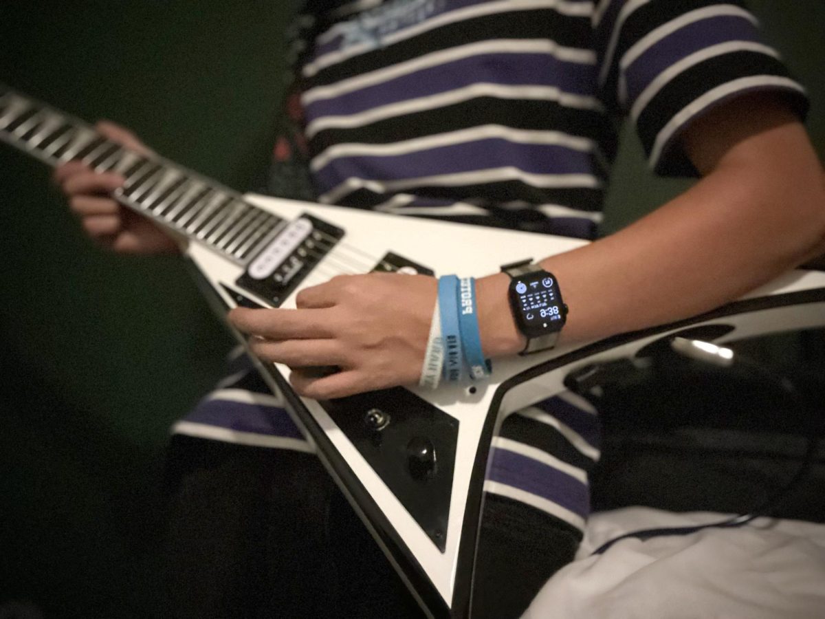 Freshman Skyler Sarabia strums his black electric guitar. "I was more drawn to the guitar than other instruments because of the different types of music I always listened to," Sarabia said.