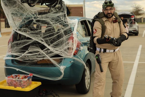 Aiming his gadget, American Sign Language teacher Brendon Feagans dresses as a Ghostbuster with a proton pack secured to his back.