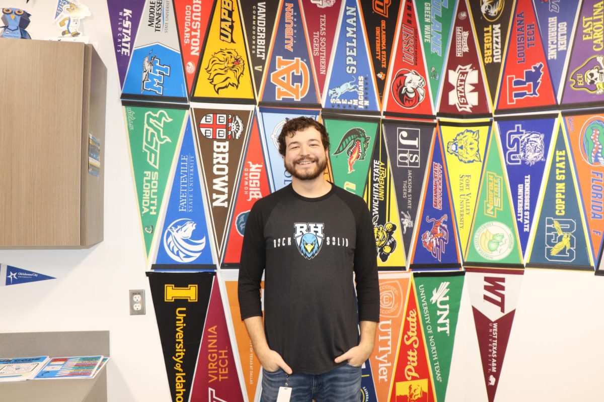 College and career counselor Gary Livingston stands in front of college banners in his office. “The most important aspect is to truly know that this is for them,” Livingston said. “This isn't for Mom, this isn't for Dad, this isn't for Auntie, Uncle, you know, it's their future.”
