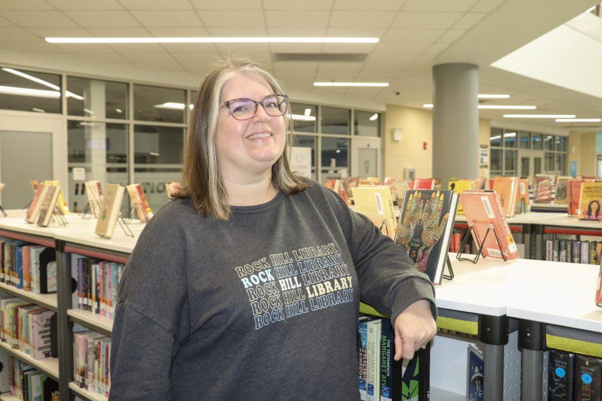 Librarian Brenda Briley stands amidst autumn-colored book displays. "I hope that everyone can come in and see themselves in not just the literature, but feel comfortable coming to me about whatever they might need," Briley said.
