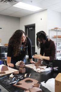 Ceramics teacher Lauren Rivera-Hesson assists a student with their clay project. "At the end of the day, it limits the high quality supplies that we can offer kids," Rivera-Hesson said. 