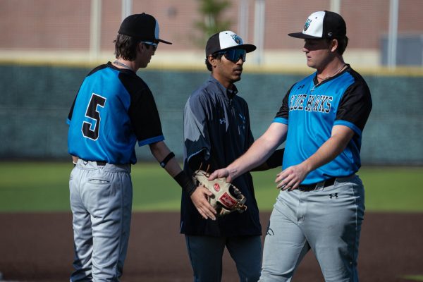 Sophomore Grayson Richards and Sophomore Cooper Adams exchange a high-five as they switch positions on the field.